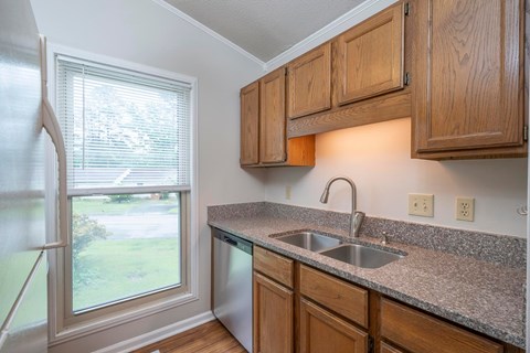 A kitchen with wooden cabinets and granite countertops.