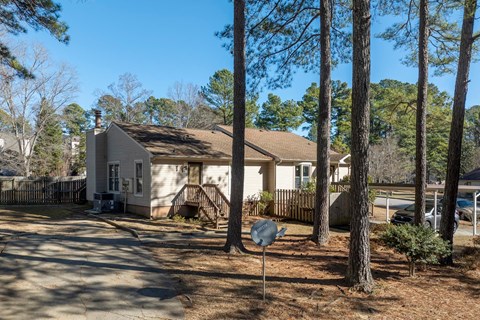A house with a brown roof is surrounded by trees.