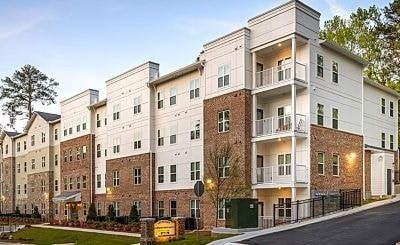A large, modern apartment building with a mix of brick and white exterior walls.