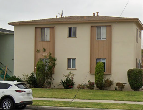 A white car is parked in front of a two-story house.