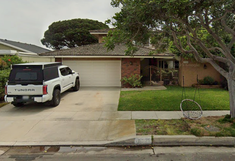 A white Tundra truck is parked in front of a house.