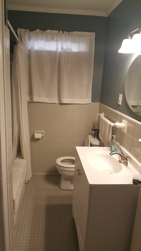 A bathroom with a toilet, sink, and shower curtain.
