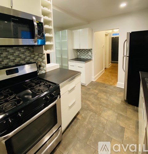 A kitchen with black appliances and white cabinets.