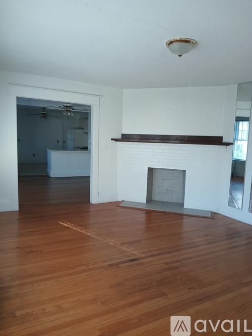 A room with a fireplace and wooden floors.