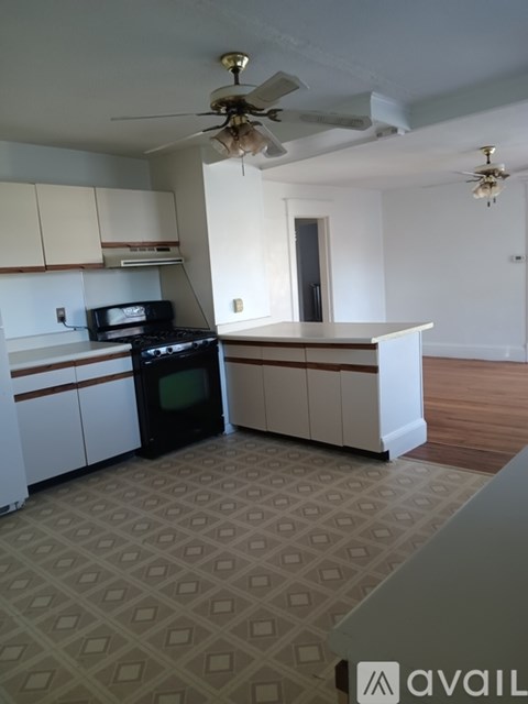 A kitchen with a black oven and white cabinets.