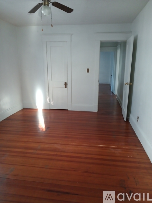 A room with a wooden floor and a ceiling fan.