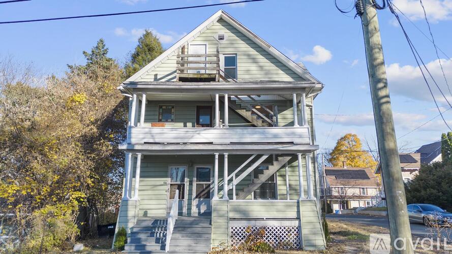 A two-story house with a porch and a balcony.