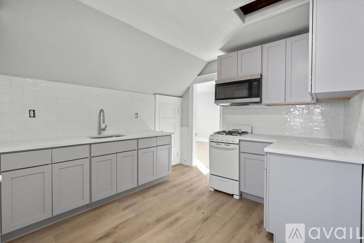 A kitchen with white cabinets and a wooden floor.