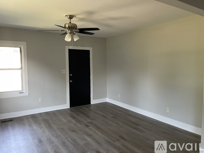 A room with a ceiling fan and a door.
