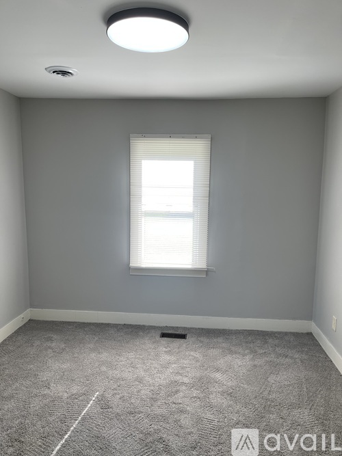 A room with a window and Avail sign on the floor.