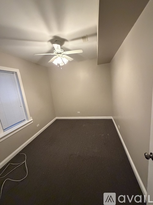 A room with a ceiling fan and a window.