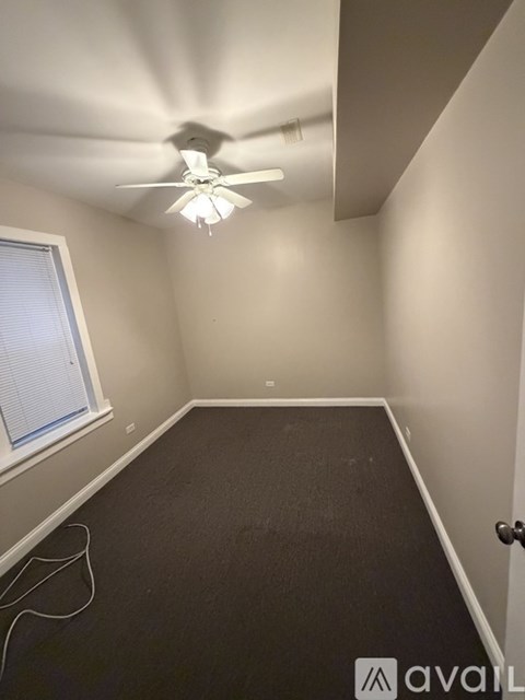 A room with a ceiling fan and a window.