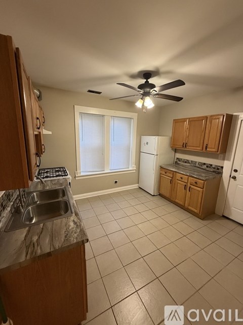 A kitchen with a marble countertop and a ceiling fan.