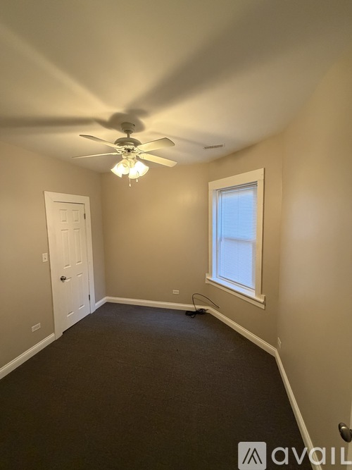 A room with a ceiling fan and a window.