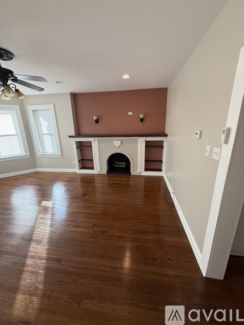 A room with a fireplace and a ceiling fan.