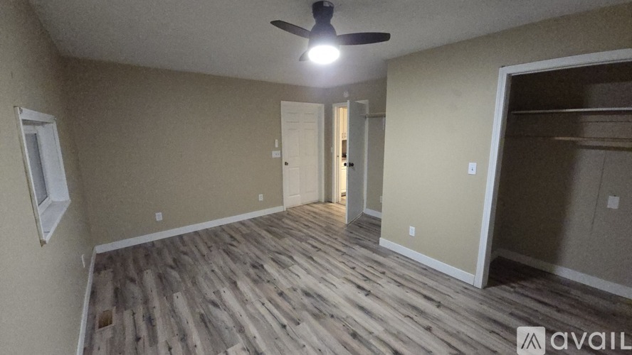 A room with wooden flooring and a ceiling fan.