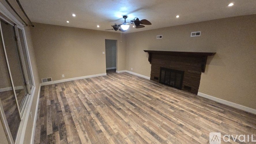 A room with wooden flooring and a fireplace.
