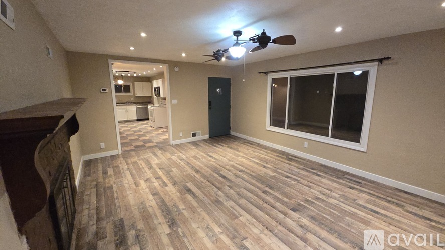 A room with wooden flooring and a ceiling fan.