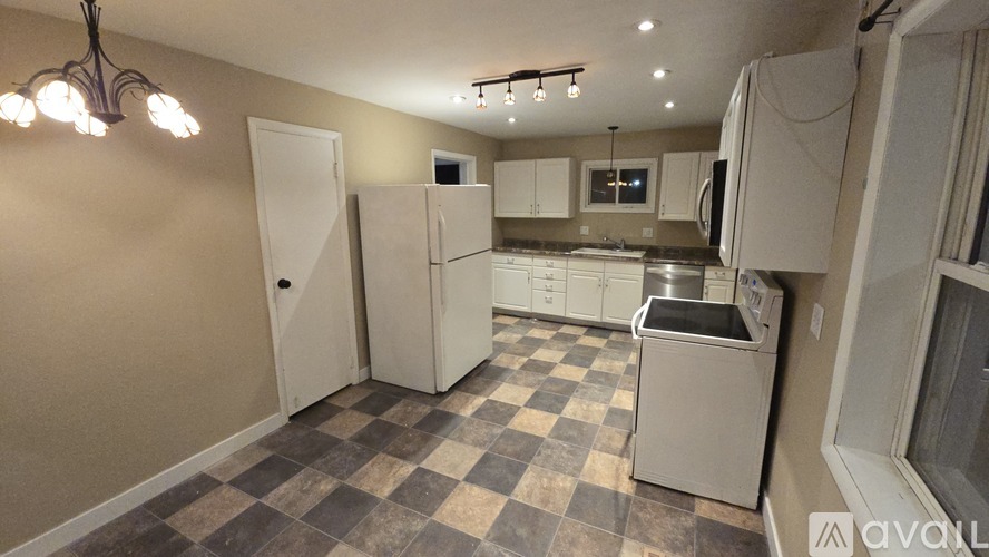 A kitchen with a checkered floor and white appliances.