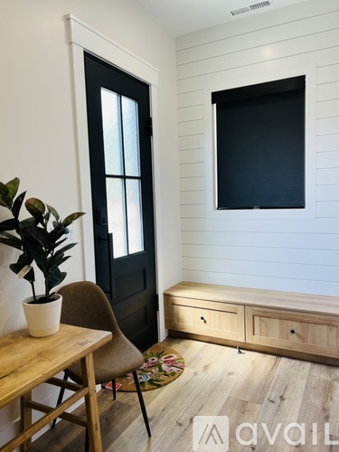 A room with a wooden table and a chair with a potted plant on it.