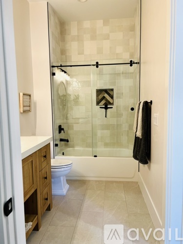 A bathroom with a glass shower door and a toilet.