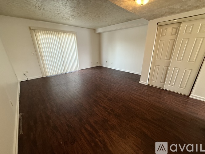 A room with wooden flooring and a white door.