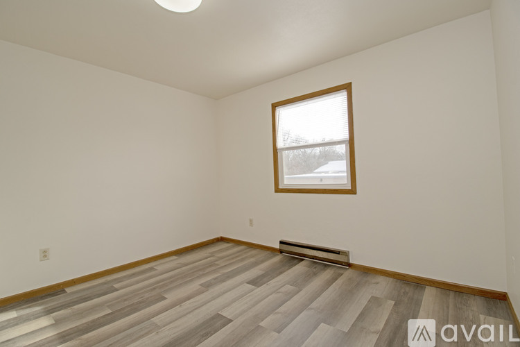 A room with a wooden floor and a window.