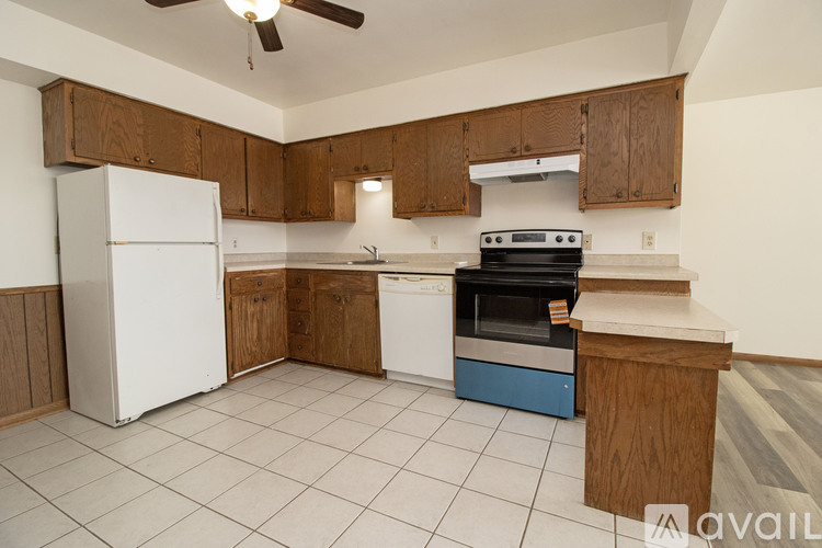 A kitchen with white appliances and wooden cabinets.