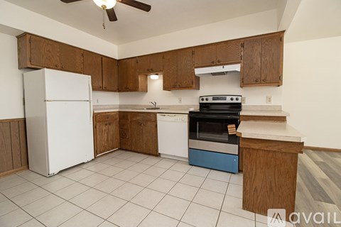 A kitchen with white appliances and wooden cabinets.