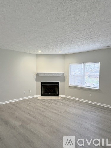 A living room with a fireplace and a window.