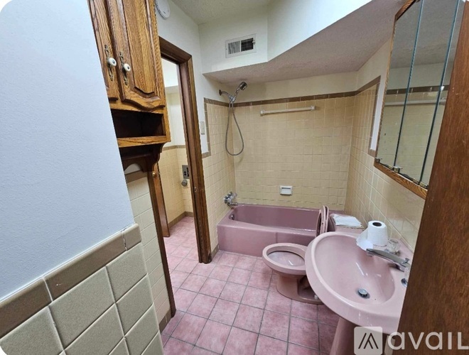 A bathroom with a pink sink and a pink tub.