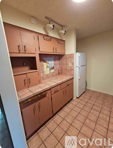 A kitchen with brown cabinets and a white refrigerator.