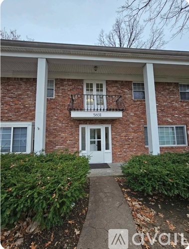 A brick house with a white door and windows.