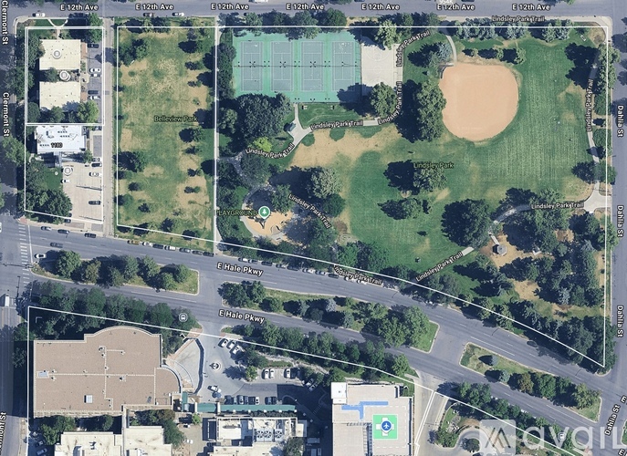 A satellite image of a city area with roads, buildings, and a tennis court.