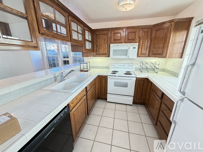A kitchen with wooden cabinets and white appliances.