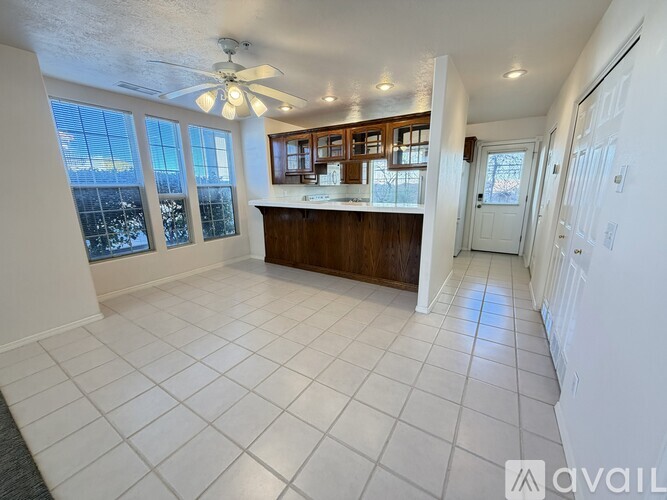 A spacious room with a fan and tile flooring.