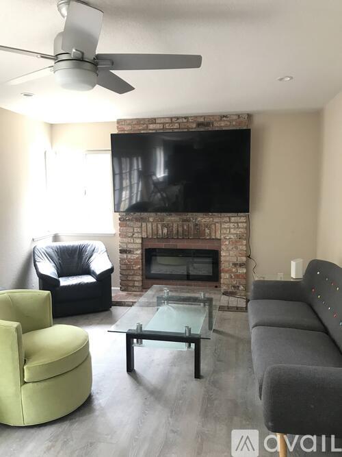 A living room with a fireplace, a television, and a glass coffee table.