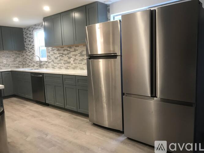 A modern kitchen with a stainless steel refrigerator and cabinets.