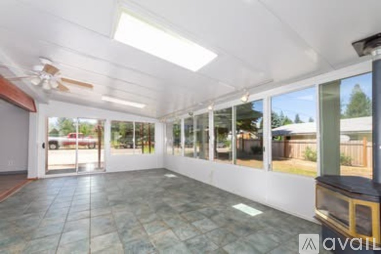 A spacious room with tiled flooring and a ceiling fan.