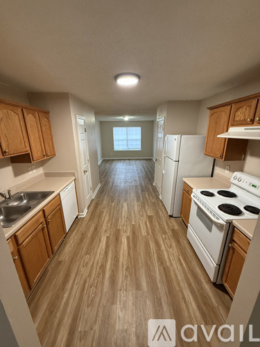 A kitchen with wooden cabinets and a white stove top oven.