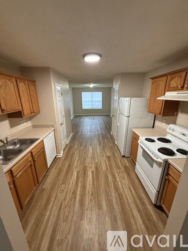 A kitchen with wooden cabinets and a white stove top oven.