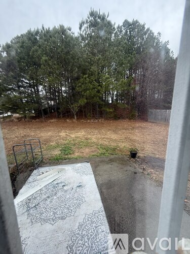 A view from a window looking out to a yard with trees.