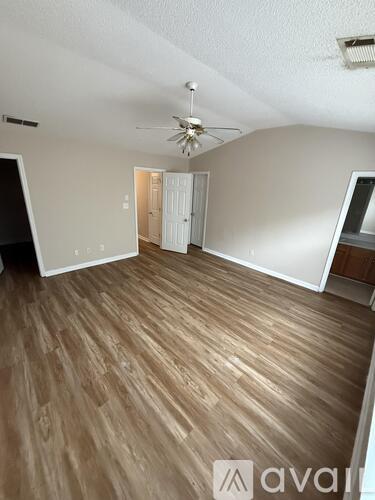 A room with wooden flooring and a ceiling fan.