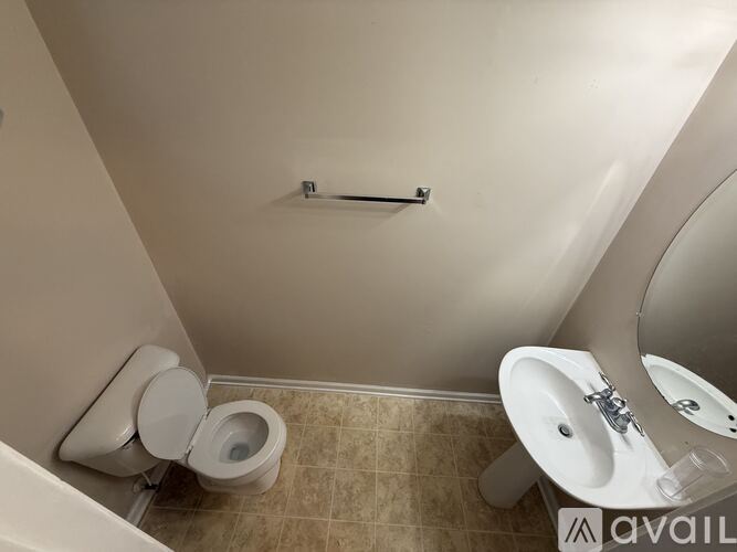 A bathroom with a toilet, sink, and towel rack.