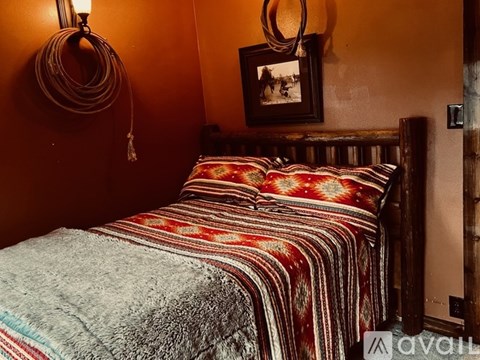 A bed with a striped comforter and a picture frame on the wall.