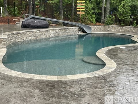 A small, round, in-ground pool with a stone border.