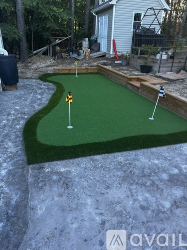 A miniature golf course with a green mat and a hole with a flag.