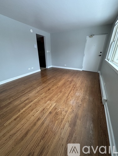 A room with wooden flooring and white walls.