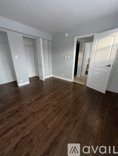 A room with wooden flooring and white walls.