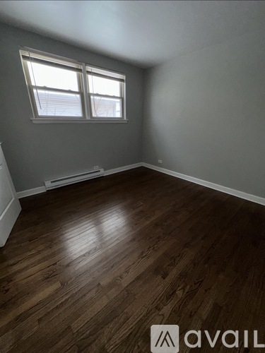 A room with wooden flooring and a window.